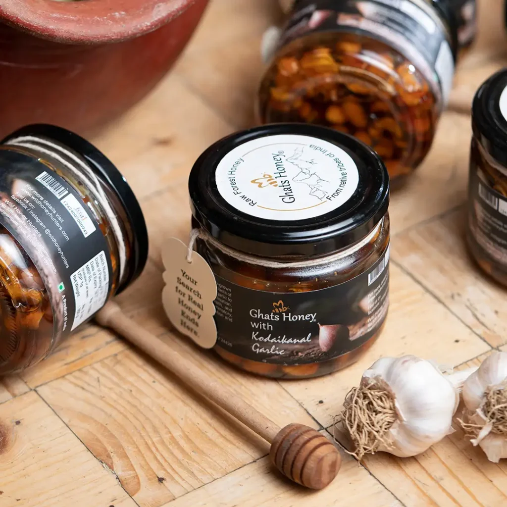 kodaikanal garlic with hiney bottle natural backround with real garlic and honey stick