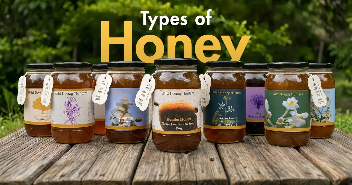 Multiple varieties of Ghats Honey displayed outdoors on a wooden table with the title "Types of Honey," highlighting the brand's range of forest honey varieties.