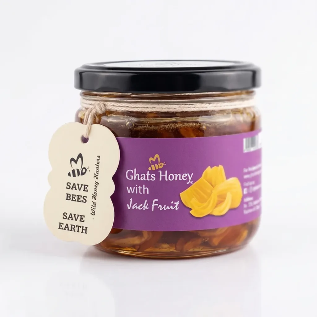 Front view of Ghats Honey with Jackfruit jar filled with jackfruit pieces in wild honey, a purple label and eco-friendly "Save Bees Save Earth" tag.