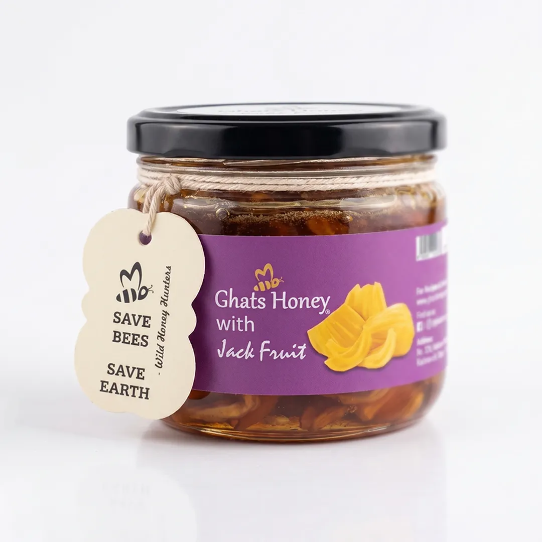 Front view of Ghats Honey with Jackfruit jar filled with jackfruit pieces in wild honey, a purple label and eco-friendly "Save Bees Save Earth" tag.